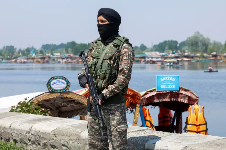 A member of India's security forces stands guard on the banks of Dal Lake, following an attack near south Kashmir's Pahalgam, in Srinagar