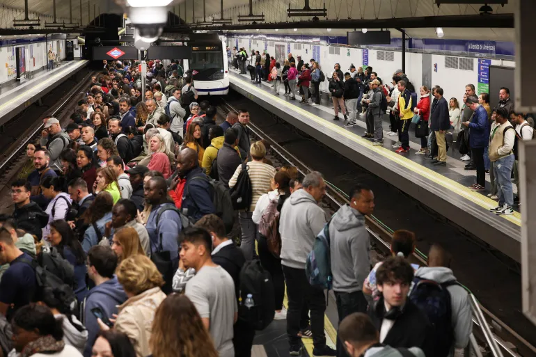 Passengers in the Spanish capital Madrid wait on a platform as metro operations resume partially, after power begins to return following a huge outage in Spain and Portugal