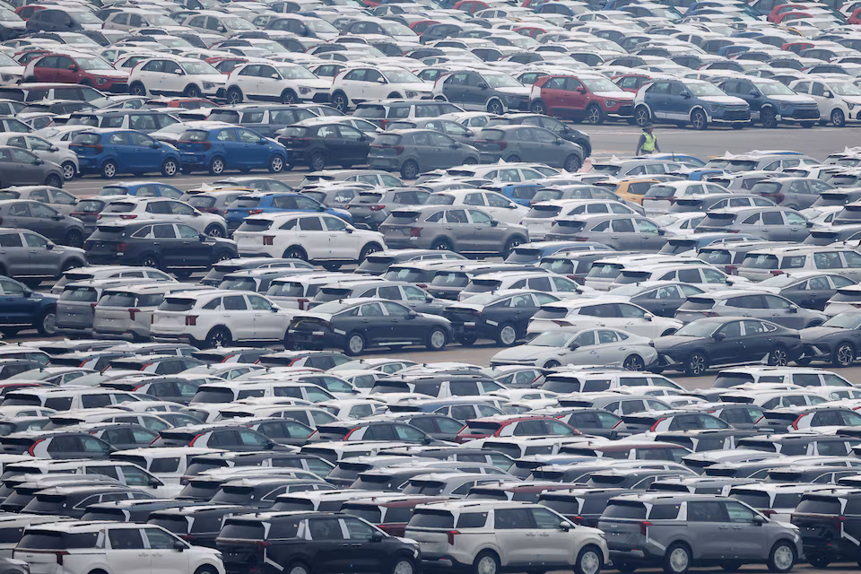 A worker walks past cars made by South Korea's automaker Kia Motors which is a sister company of South Korea’s biggest automaker company Hyundai Motors at the company's shipping yard at a port in Pyeongtaek, South Korea, April 2, 2025.